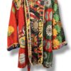 Veste kantha vintage réversible en coton recyclé, faite main à partir de saris indiens – pièce unique aux motifs fleuris colorés, exposée sur un portant. Rouge, vert, fleurs