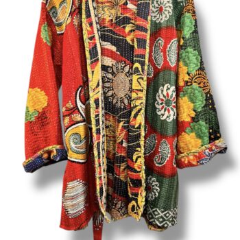 Veste kantha vintage réversible en coton recyclé, faite main à partir de saris indiens – pièce unique aux motifs fleuris colorés, exposée sur un portant. Rouge, vert, fleurs