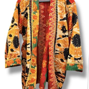 Veste kantha vintage réversible en coton recyclé, faite main à partir de saris indiens – pièce unique aux motifs fleuris colorés, exposée sur un portant. Rouge, vert, fleurs, orange, reversilble
