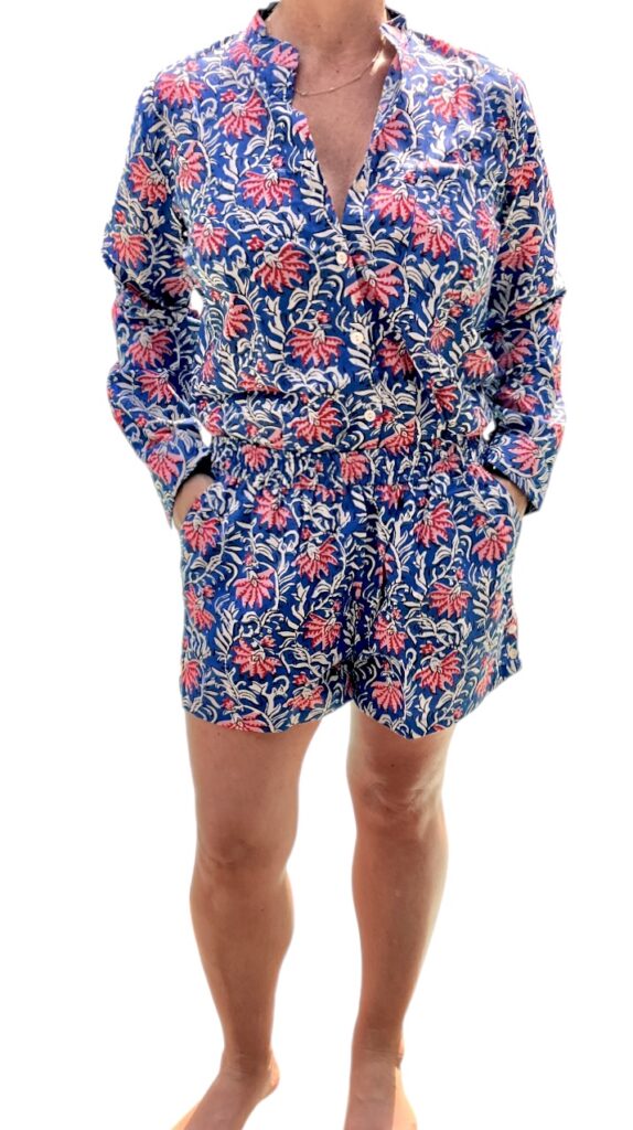 Cet ensemble unique associe le charme de l’artisanat indien et le savoir-faire de notre atelier bordelais. La chemise à col Mao, élégamment boutonnée avec de sublimes boutons en nacre, est imprimée à la main selon la technique ancestrale du block print en Inde. Le short assorti reprend les mêmes imprimés et se distingue par ses finitions soignées : poches latérales et arrières, petits boutons délicats sur les côtés, cuisses en nacre… chaque détail compte. Un look à la fois décontracté et raffiné, pensé pour celles qui aiment porter des pièces uniques, responsables et empreintes de voyage. Créé avec amour à Bordeaux, fabriqué à la main entre ici et ailleurs. Imprimé blockprint fleurs rose et bleu marine