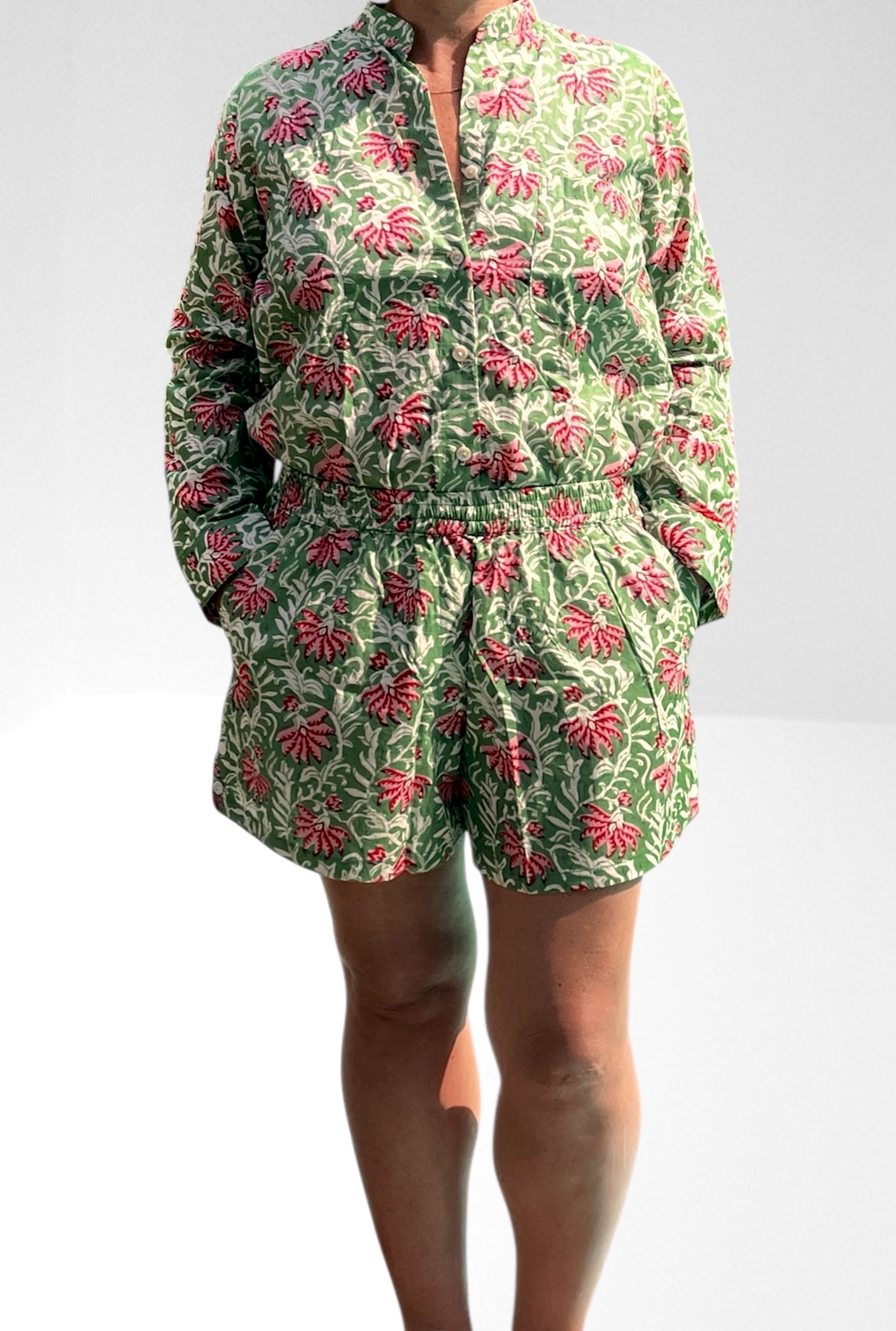 Cet ensemble unique associe le charme de l’artisanat indien et le savoir-faire de notre atelier bordelais. La chemise à col Mao, élégamment boutonnée avec de sublimes boutons en nacre, est imprimée à la main selon la technique ancestrale du block print en Inde. Le short assorti reprend les mêmes imprimés et se distingue par ses finitions soignées : poches latérales et arrières, petits boutons délicats sur les côtés, cuisses en nacre… chaque détail compte. Un look à la fois décontracté et raffiné, pensé pour celles qui aiment porter des pièces uniques, responsables et empreintes de voyage. Créé avec amour à Bordeaux, fabriqué à la main entre ici et ailleurs. Tissu fleuri vert et rose