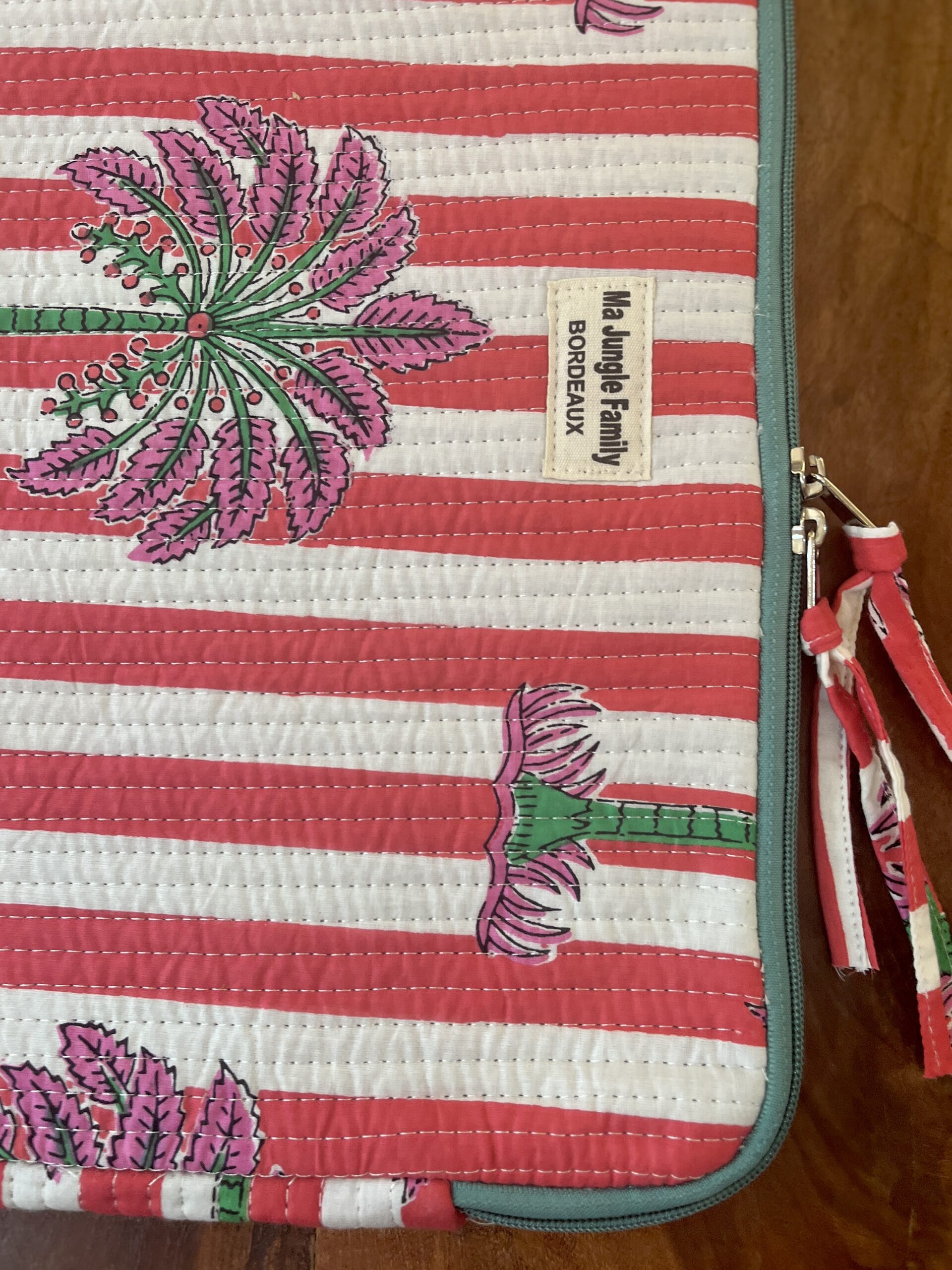 Housse d’ordinateur en coton indien matelassé avec imprimé floral block-print, format 15 pouces, faite main. Housse d’ordinateur artisanale en coton indien, motif original, utilisée pour transporter un laptop, Accessoire éthique : housse ordinateur bohème en coton imprimé, tenue à la main dans un décor naturel. Housse d’ordinateur Ma Jungle Family – coton indien artisanal – Bordeaux Fleuriste colorés hibiscus vert et orange, rouge palmier