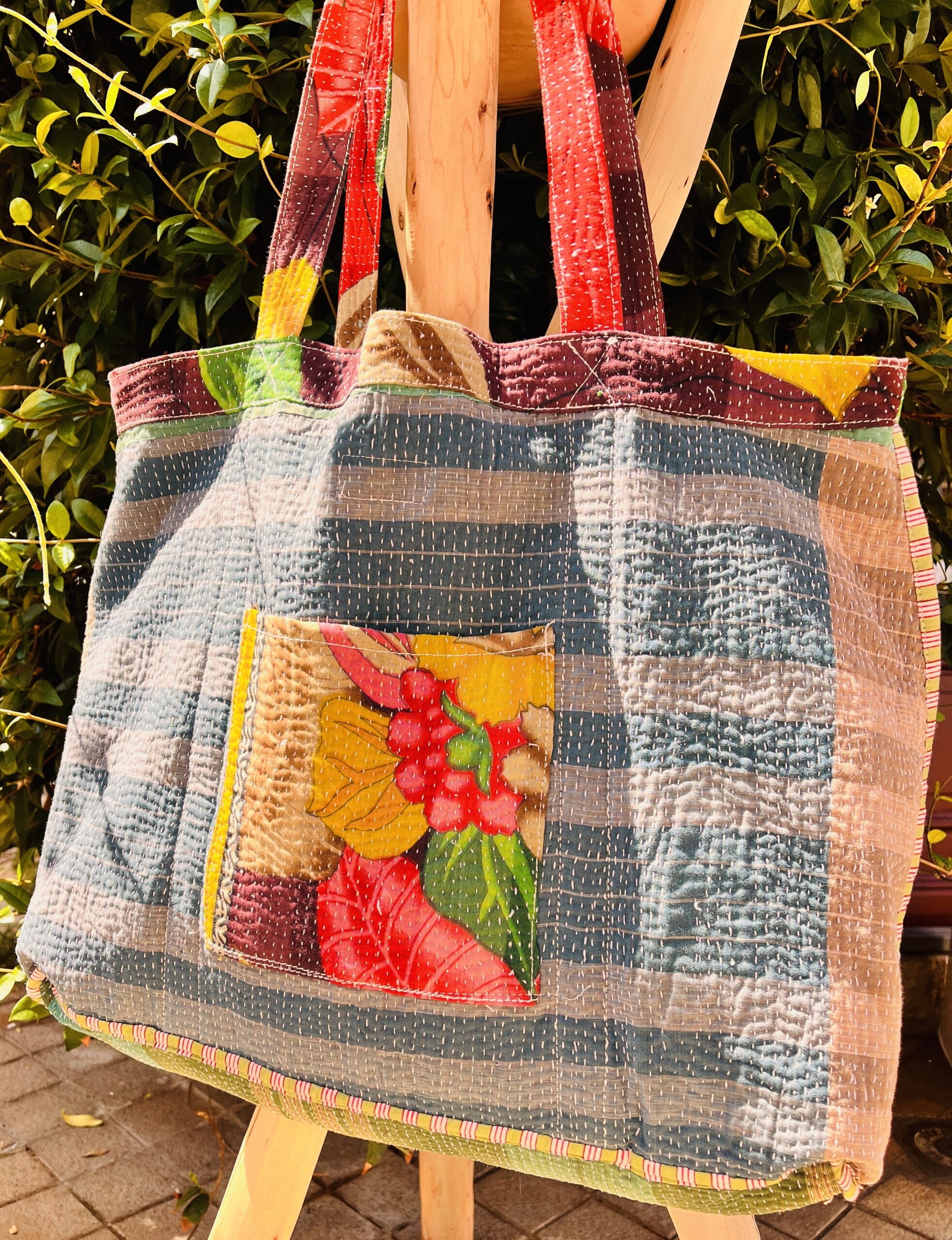 Tote bag kantha réversible en coton recyclé, cousu main à partir de saris indiens, avec poche extérieure et intérieure – modèle unique exposé en lumière naturelle.