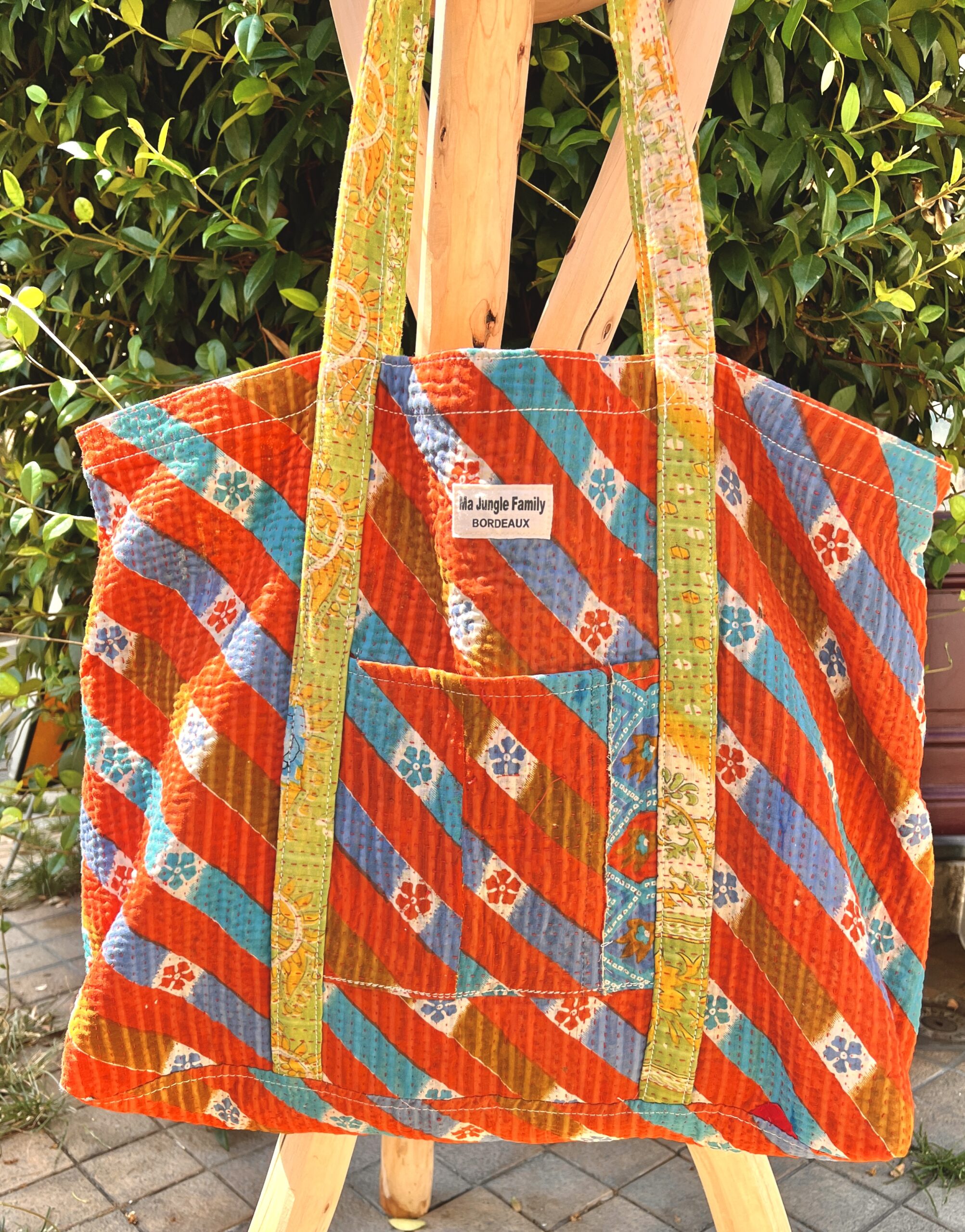 Tote bag kantha réversible en coton recyclé, cousu main à partir de saris indiens, avec poche extérieure et intérieure – modèle unique exposé en lumière naturelle.
