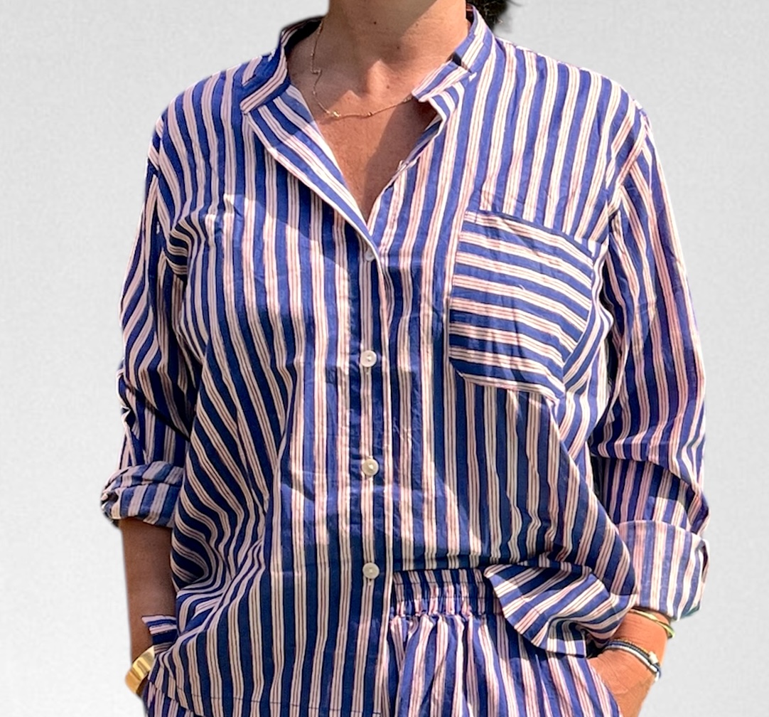 Cet ensemble unique associe le charme de l’artisanat indien et le savoir-faire de notre atelier bordelais. La chemise à col Mao, élégamment boutonnée avec de sublimes boutons en nacre, est imprimée à la main selon la technique ancestrale du block print en Inde. Le short assorti reprend les mêmes imprimés et se distingue par ses finitions soignées : poches latérales et arrières, petits boutons délicats sur les côtés, cuisses en nacre… chaque détail compte. Un look à la fois décontracté et raffiné, pensé pour celles qui aiment porter des pièces uniques, responsables et empreintes de voyage. Créé avec amour à Bordeaux, fabriqué à la main entre ici et ailleurs. Tissu fleuri vert et rose, rayures bleues