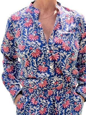 Cet ensemble unique associe le charme de l’artisanat indien et le savoir-faire de notre atelier bordelais. La chemise à col Mao, élégamment boutonnée avec de sublimes boutons en nacre, est imprimée à la main selon la technique ancestrale du block print en Inde. Le short assorti reprend les mêmes imprimés et se distingue par ses finitions soignées : poches latérales et arrières, petits boutons délicats sur les côtés, cuisses en nacre… chaque détail compte. Un look à la fois décontracté et raffiné, pensé pour celles qui aiment porter des pièces uniques, responsables et empreintes de voyage. Créé avec amour à Bordeaux, fabriqué à la main entre ici et ailleurs. Imprimé blockprint fleurs rose et bleu marine